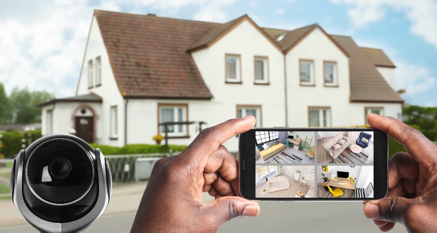 Man holding smartphone and looking at footage from video cameras