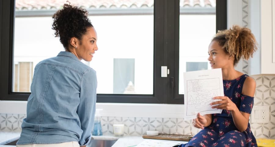 Mother and daughter in front of a window with an ADT contact sensor